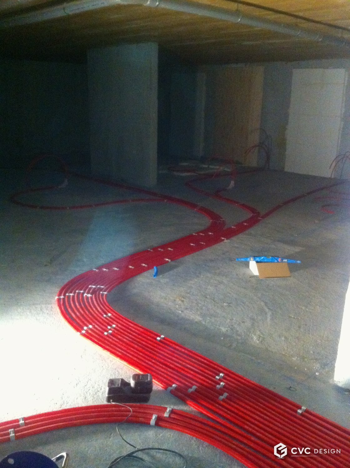 Tubes de chauffage sous fourreaux rouges fixés au sol avant coulage — incorporation du réseau de chauffage en dalle — Drancy
